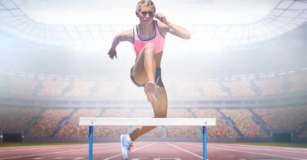 Composite Image Caucasian Female Athlete Jumping Hurdles Sports Stadium Sports — Zdjęcie stockowe