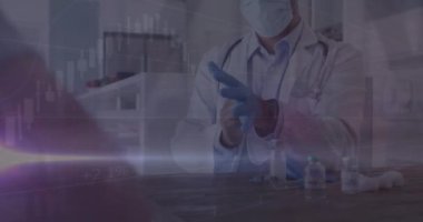 Yüz maskesi ve eldivenleri olan beyaz bir erkek doktor üzerinde veri işleme animasyonu. covid 19 salgın konsepti sırasında dijital olarak üretilen video boyunca küresel tıp ve veri işleme.