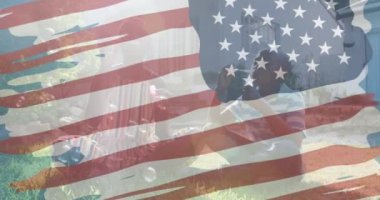 Afro-Amerikan annesinin oğluyla baloncuk çıkarması üzerine Amerikan bayrağının animasyonu. Vatanseverlik ve kutlama konsepti dijital olarak oluşturulmuş video.