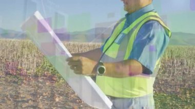 Melez mühendis üzerinde proje ve rüzgar türbinli grafiklerin animasyonu. Ekonomi, sürdürülebilirlik ve yenilenebilir enerji konsepti dijital olarak oluşturulmuş video.