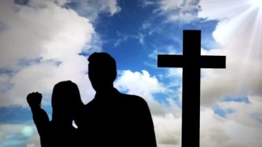 Bulut ve haç üzerindeki çiftlerin siluetinin animasyonu. din ve inanç kavramı dijital olarak oluşturulan video.