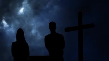 Bulut ve haç üzerindeki çiftlerin siluetinin animasyonu. din ve inanç kavramı dijital olarak oluşturulan video.