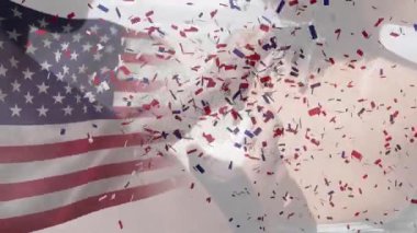 Sahildeki Afro-Amerikan çifti üzerinde Amerikan bayrağı ve konfeti animasyonu. Vatanseverlik ve kutlama konsepti dijital olarak oluşturulmuş video.