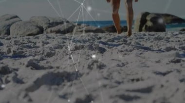 Kumsalda voleybol oynayan beyaz bir kadının bacakları üzerinden bağlantı animasyonu. spor aktif yaşam tarzı, bağlantılar, teknoloji ve dijital arayüz konsepti dijital olarak oluşturulmuş video.