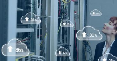 Animation of clouds with increasing numbers over smiling caucasian woman standing at servers. cloud computing, data uploading, computers and technology concept digitally generated video.