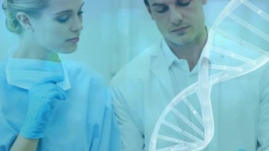 Tablet kullanan beyaz kadın ve erkek doktor üzerinde dönen DNA ipliklerinin animasyonu. küresel tıp, veri işleme ve dijital arayüz kavramı dijital olarak oluşturulmuş video.