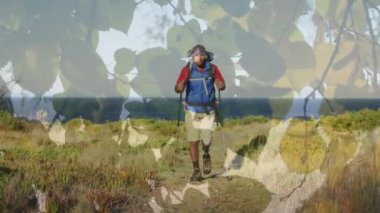 Ağaçtaki yeşil yaprakların birleşik videosu dağlarda yürüyüş yapan Afrikalı Amerikalılara karşı. Ulusal Yürüyüş Günü Farkındalığı