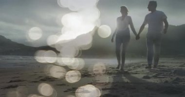 Kumsalda yürüyen beyaz bir çifte karşı ışığın birleşik videosu. Ulusal Yürüyüş Günü Farkındalığı