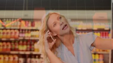 Dükkanda gülümseyen beyaz bir kadının akıllı telefondan konuşması üzerine veri işleme animasyonu. küresel iş, finans, bağlantılar ve dijital arayüz konsepti dijital olarak oluşturulmuş video.