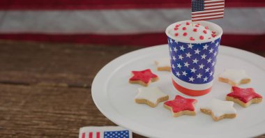 Bardakta içki, tahta yüzeyde kurabiye ve fotokopi alanı olan minyatür Amerikan bayrağı. Amerikan bağımsızlığı ve vatanseverlik kavramı