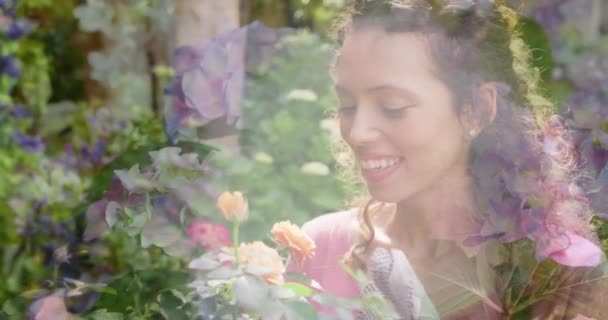 Animación Luces Brillantes Sobre Feliz Mujer Birracial Oliendo Flores Jardín — Vídeo de stock