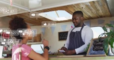 Animation of social media icons and numbers over african american man and woman in food truck. fashion and lifestyle concept digitally generated video.