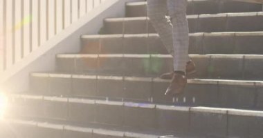 Merdivenlerden inen iş adamının alçak kısmının üzerinde parlayan ışıkların canlandırması. iş günü konseptine yürüyün dijital olarak oluşturulan video.