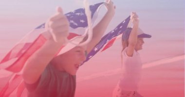 Kumsalda koşan Amerikan bayraklı beyaz erkek ve kız kardeşler. Ulusal Kardeşler Günü farkındalık kavramı