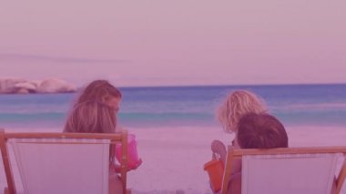 Kovalar taşıyan iki beyaz kız kardeş sahilde birlikte oynuyorlar. Ulusal Kardeşler Günü farkındalık kavramı