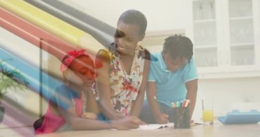 Multiple colored pencils against african american mother helping her daughter with her homework. school and education concept