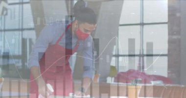 Yüz maskesi takıp masayı temizleyen Afro-Amerikan erkek garsona karşı istatistiksel veri işleme. iş ve teknoloji kavramı