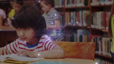 Okuldaki kütüphanede okuyan bir çocuğa karşı parlayan bir bağlantı ağı. Okula ve eğitim konseptine dönüş