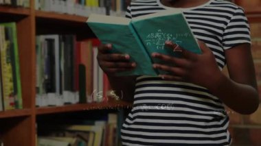 Kütüphanede kitap okuyan Afrikalı Amerikalı kızlara karşı yüzen matematiksel denklemler. Okula ve eğitim konseptine dönüş