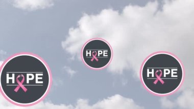 Bulutlu gökyüzünde pembe kurdele ve umut mesajı animasyonu. Göğüs kanseri pozitif farkındalık kampanyası konsepti dijital olarak üretildi.