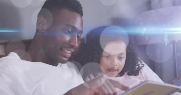 Animacja Plamek Świetlnych Nad Szczęśliwym Afro Amerykańskim Ojcem Czytającym Książkę — Wideo stockowe