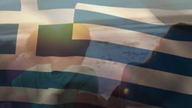 Sahildeki bir grup arkadaşın üzerinde Yunan bayrağı sallama animasyonu. seyahat ve tatil konsepti dijital olarak oluşturulmuş video.