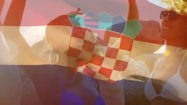 Sahildeki bir grup arkadaşın üzerinde Hırvat bayrağı sallama animasyonu. seyahat ve tatil konsepti dijital olarak oluşturulmuş video.