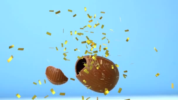 Animation Gold Confetti Falling Chocolate Easter Egg Falling Breaking Blue — Stock Video