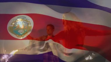 Sahildeki bir grup arkadaşın üzerinde Costa rica bayrağı sallamanın animasyonu. seyahat ve tatil konsepti dijital olarak oluşturulmuş video.