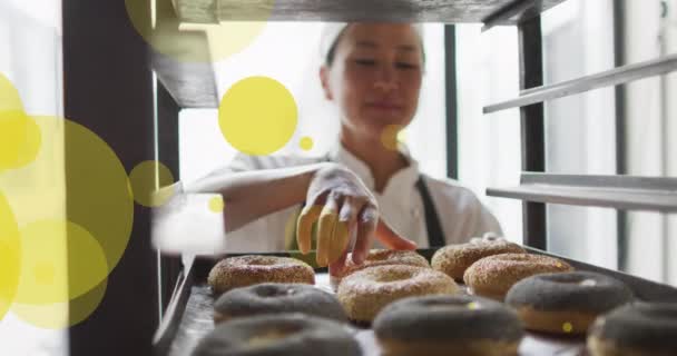 Animación Manchas Verdes Sobre Hembra Asiática Panadero Preparando Rosquillas Día — Vídeos de Stock