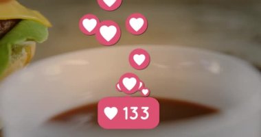 Hamburgerin yanında kalp ve sosyal medya tepkilerinin animasyonu. Amerikan mutfağı ve fast food konsepti dijital olarak üretiliyor..