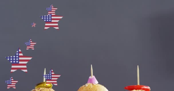 木製の板の上に横たわるハンバーガーの上にウサの旗を持つ星のアニメーション アメリカ料理とファーストフードのコンセプトをデジタルで生成したビデオ — ストック動画