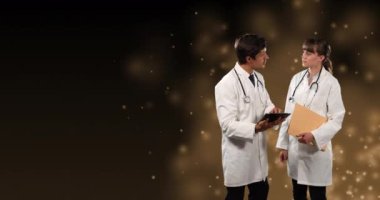 Beyaz erkek ve kadın doktorların siyah arka plandaki ışık noktalarından hareketlenmeleri. Kamu hizmeti günü ve dijital olarak oluşturulan video konsepti.