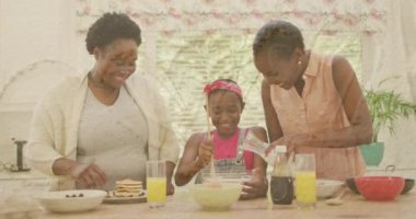 Sand on the beach against african american grandmother, mother and granddaughter baking together. cooking concept