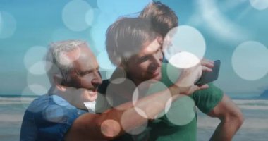 Bokeh 'in mutlu beyaz büyükbaba, baba ve oğlunun sahilde selfie çekmesi üzerine animasyonu. aile ve birlikte kaliteli zaman geçirme kavramı dijital olarak oluşturulmuş video.