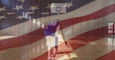 Amerikan bayrağı, basketbol antrenmanı yapan Afro-Amerikan erkek basketbolcuya karşı sallanıyor. spor ve spor konsepti