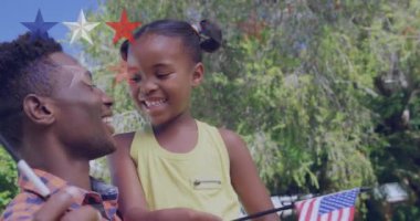 Amerikan bayraklı mutlu Afrikalı Amerikalı anne ve kızının üzerindeki yıldızların animasyonu. aile, vatanseverlik ve birlikte zaman geçirme konsepti dijital olarak oluşturulmuş video.