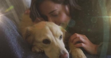 Beyaz bir kadının evinde köpeğine sarılmasına karşı bir ışık lekesi. Ulusal evcil hayvan ayı farkındalığı kavramı