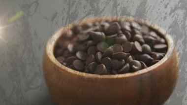 Çikolatalı cipslerin üzerindeki ışığın gri arka plandaki kasede canlandırılması. tatlılar, tatlılar ve dijital olarak üretilen çikolata konsepti.