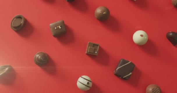 Animation Lumière Sur Les Pralines Chocolat Sur Surface Rouge Bonbons — Video