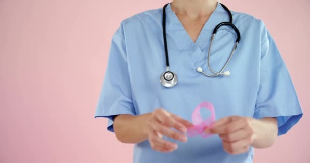 ピンクのリボンを持つ白人女性医師の中央部にわたる世界の癌の日のアニメーション がんの認知度と世界のがんの日のコンセプトをデジタルで — ストック動画