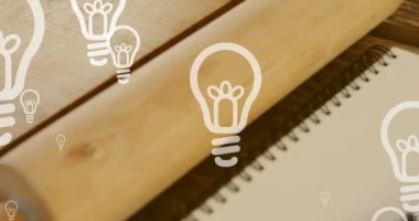 Not defteri ve kalem üzerinde ampul simgelerinin canlandırılması. Ulusal yazma günü ve dijital olarak üretilen video konsepti.