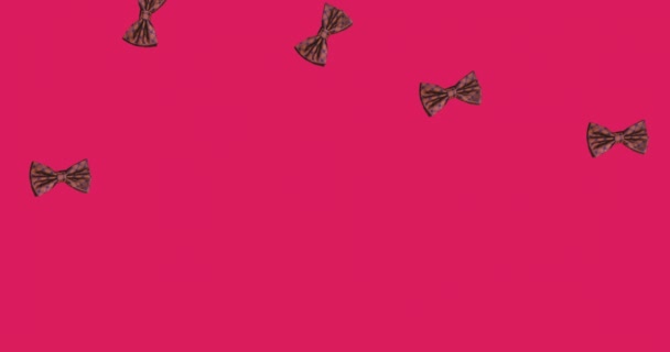 ピンクを背景に蝶ネクタイのアニメーション 服や形や動きの概念をデジタルで生成し — ストック動画