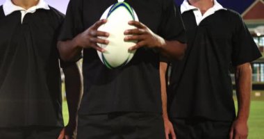 Rugby sahasında top tutan çeşitli rugby oyuncularının üzerinde parlayan ışıkların animasyonu. ragbi, spor ve yarışma konsepti dijital olarak oluşturulmuş video.