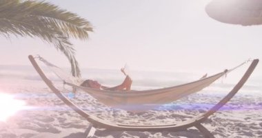 Kumsalda hamakta yatan beyaz kadının üzerindeki ışık lekelerinin canlandırması. Ulusal rahatlama günü ve dijital olarak üretilen video konsepti.