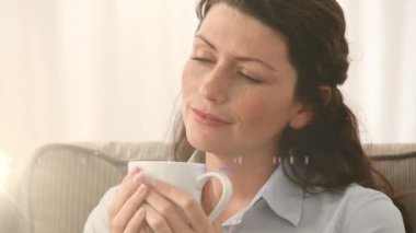 Kafkasyalı bir kadının evde kahve içmesi üzerine ışıklı noktaların canlandırılması. Ulusal rahatlama günü ve dijital olarak üretilen video konsepti.