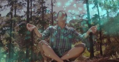 Ormanda meditasyon yapan Asyalı kadının üzerindeki ışık lekeleri. Ulusal rahatlama günü ve dijital olarak üretilen video konsepti.