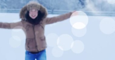 Animation of light spots over caucasian woman jumping with arms outstretched. never give up day and celebration concept digitally generated video.