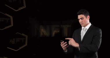 Animation of nft over nft in hexagons over caucasian businessman using smartphone. digital resources and technology concept digitally generated video.