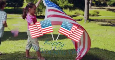 Animation of usa flags over happy biracial boy and girl running with flags on grass. presidents day, independence day and american patriotism concept digitally generated video.